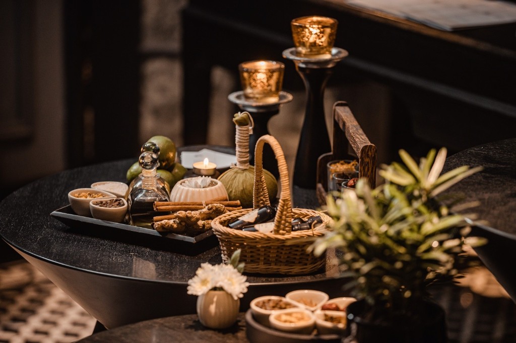 Luxury spa treatment accessories with candles and herbal compresses.